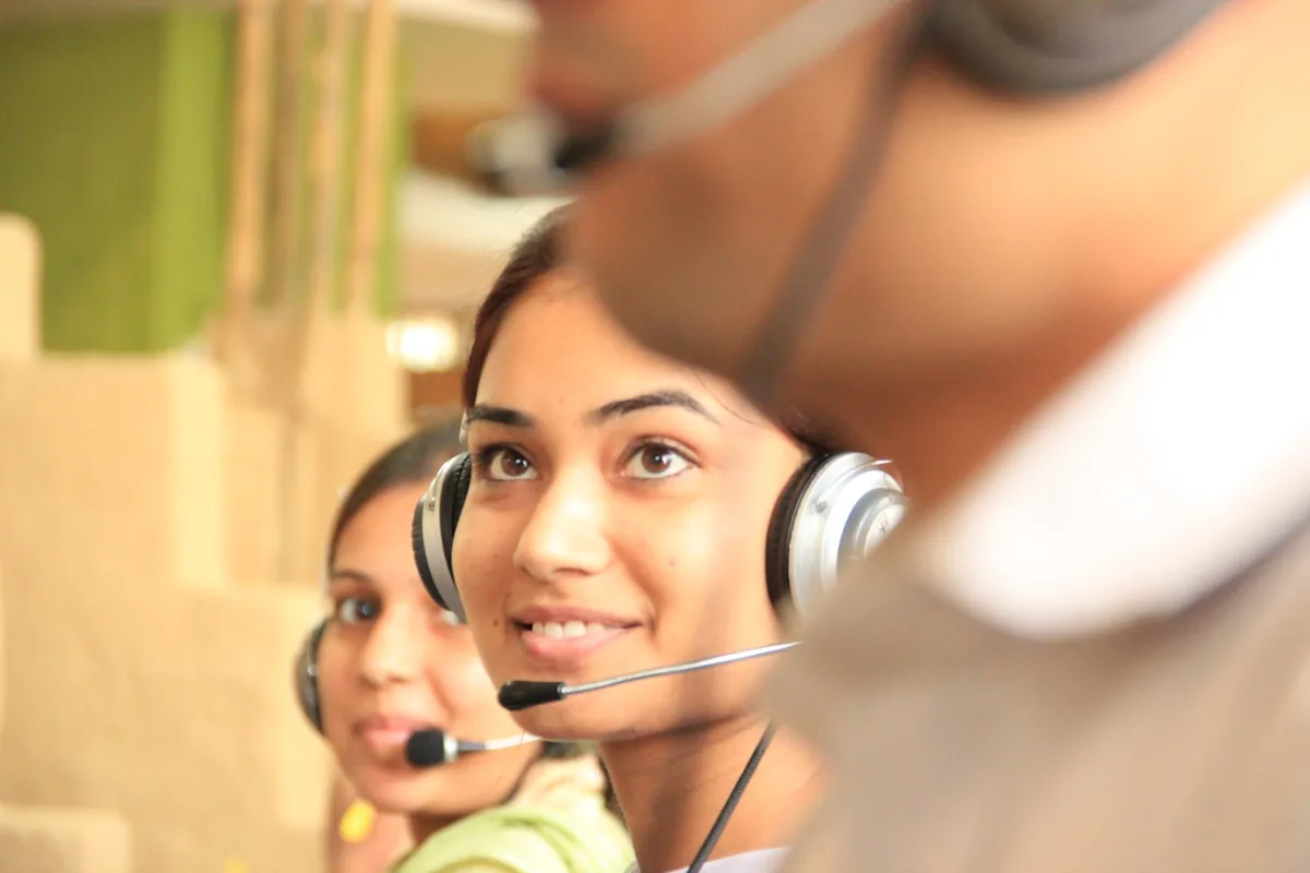Two women wearing headsets in a bright office workspace
