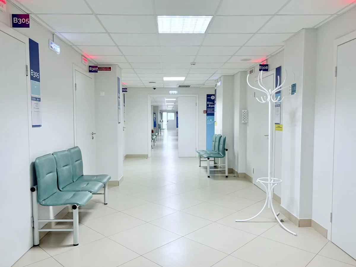 Empty hospital corridor with benches and doors